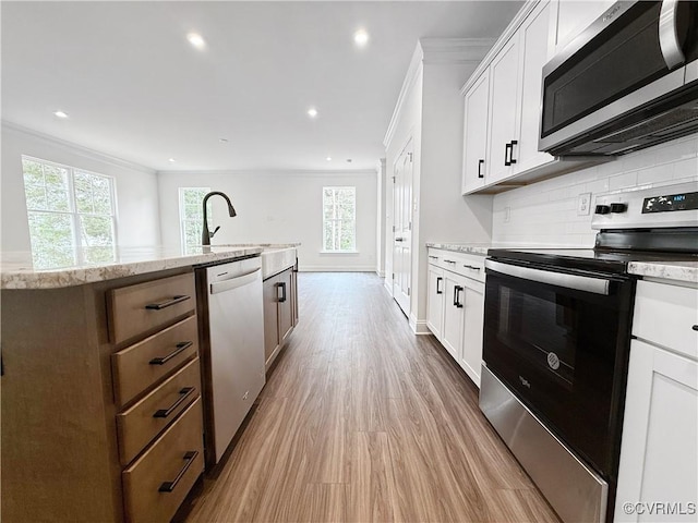 2047 Swiss Ln, Hayes, VA 23072 - kitchen with stainless steel appliances, crown molding, backsplash, plenty of natural light, and wood finished floors
