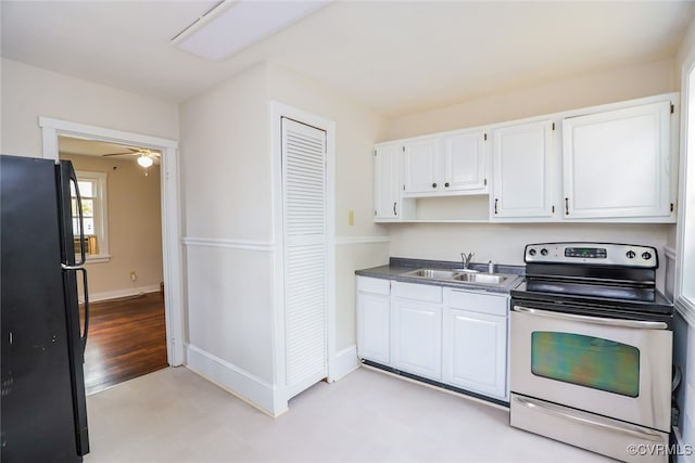 kitchen with ceiling fan, sink, stainless steel electric range, black refrigerator, and white cabinets