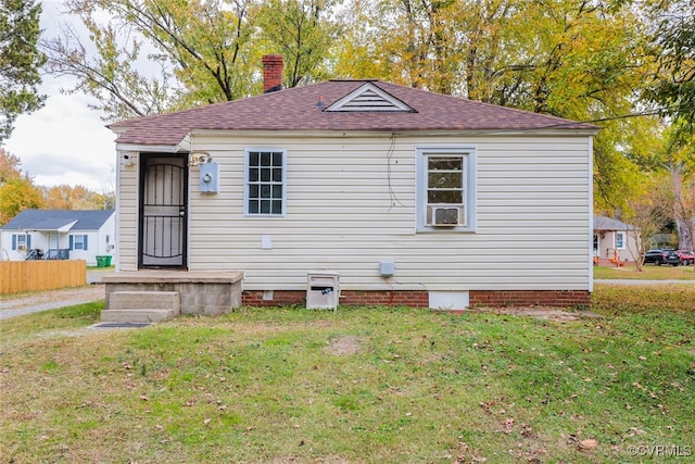 back of property featuring a lawn and cooling unit