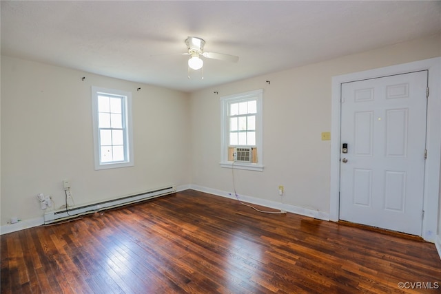 unfurnished room with dark wood-type flooring, baseboard heating, a healthy amount of sunlight, and ceiling fan