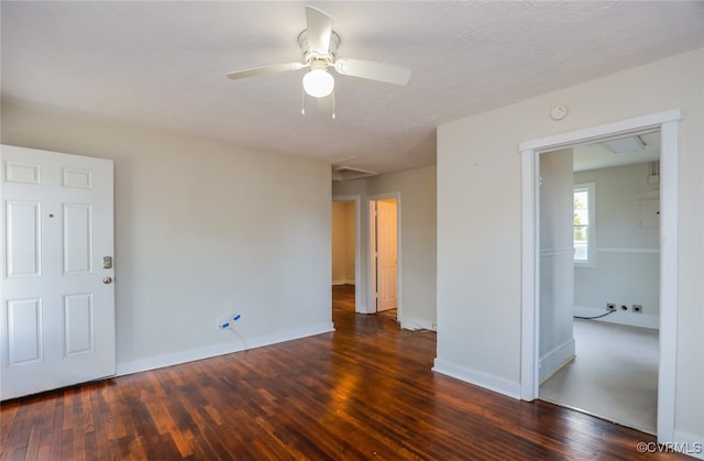 empty room with ceiling fan, dark hardwood / wood-style flooring, and a textured ceiling