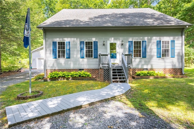 view of front of house featuring an outbuilding, a front yard, and a garage