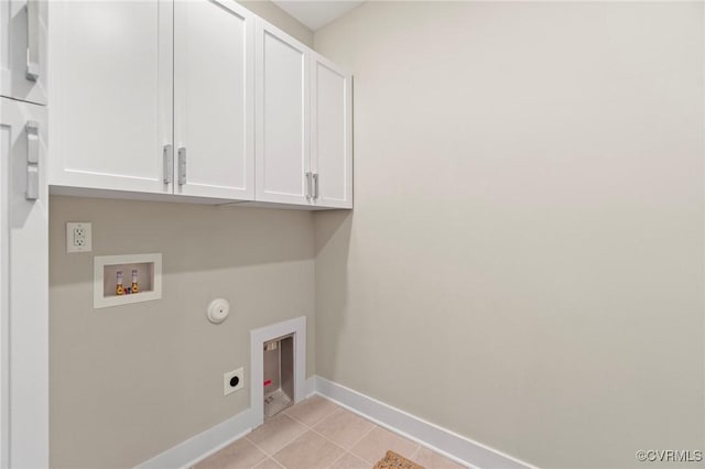 clothes washing area with washer hookup, cabinets, hookup for an electric dryer, gas dryer hookup, and light tile patterned floors