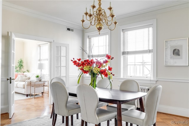 dining area featuring ornamental molding, parquet flooring, and an inviting chandelier