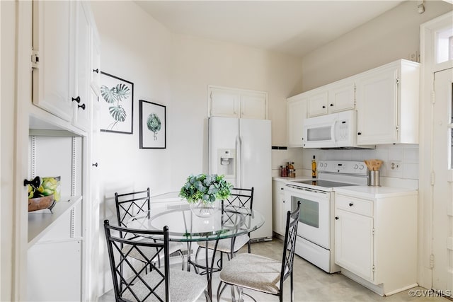 kitchen featuring white cabinetry, white appliances, and tasteful backsplash