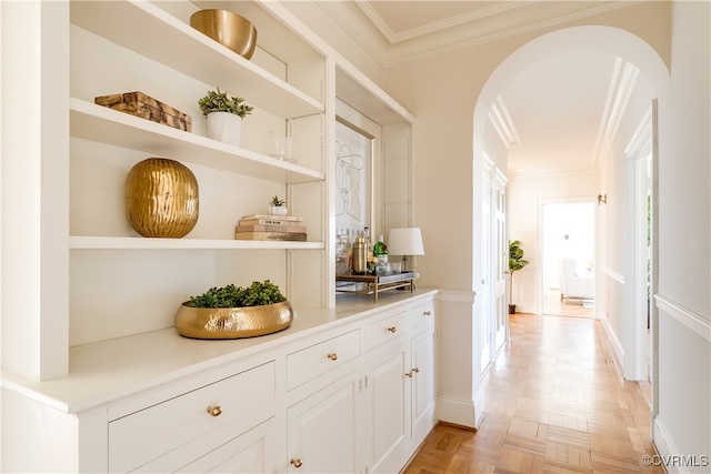 bar featuring light parquet flooring, white cabinetry, plenty of natural light, and ornamental molding