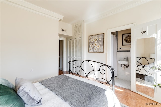 bedroom with ensuite bathroom, parquet floors, crown molding, and sink