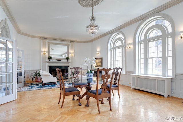 dining room with radiator heating unit, french doors, an inviting chandelier, light parquet floors, and ornamental molding