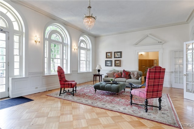 living area with light parquet floors, an inviting chandelier, plenty of natural light, and ornamental molding