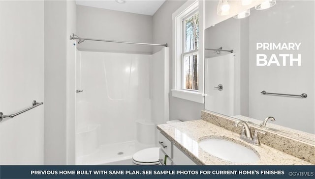 bathroom featuring toilet, a stall shower, and vanity