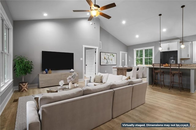 living area with ceiling fan, high vaulted ceiling, recessed lighting, and light wood-style floors