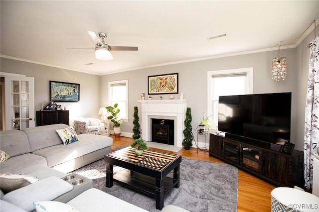 living room with ceiling fan, light hardwood / wood-style floors, and ornamental molding