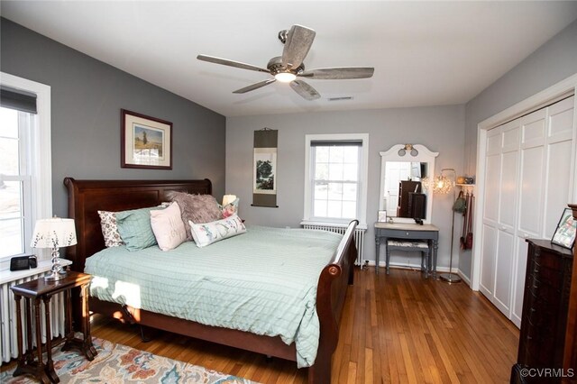 bedroom featuring ceiling fan, dark hardwood / wood-style floors, and a closet