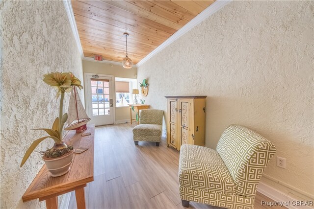 living area with light hardwood / wood-style floors, ornamental molding, and wood ceiling