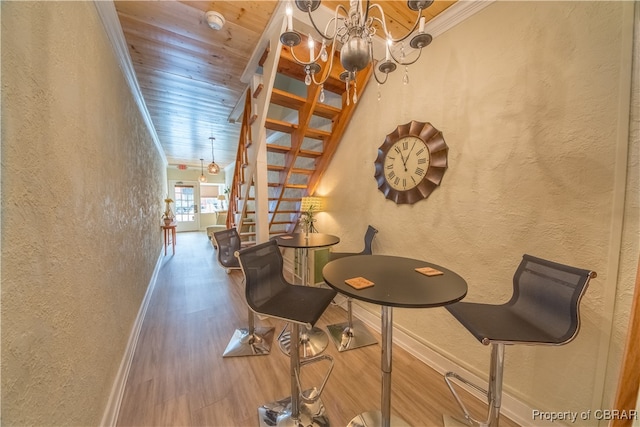 interior space featuring crown molding, hardwood / wood-style floors, wood ceiling, and a notable chandelier