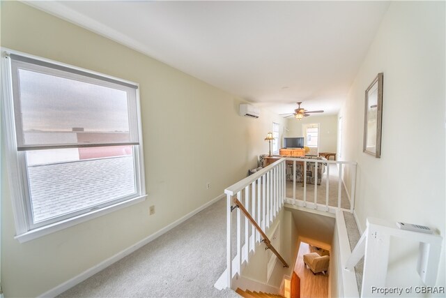 hall with carpet floors and a wall mounted AC