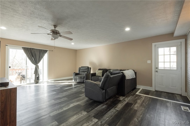 living room with plenty of natural light, dark hardwood / wood-style flooring, and a textured ceiling