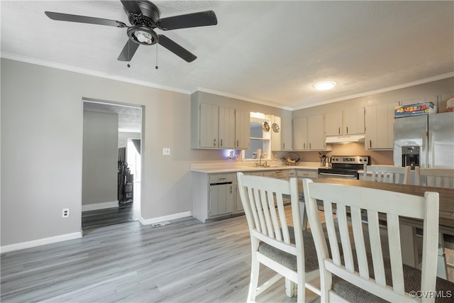 kitchen featuring sink, stainless steel appliances, light hardwood / wood-style floors, a textured ceiling, and ornamental molding