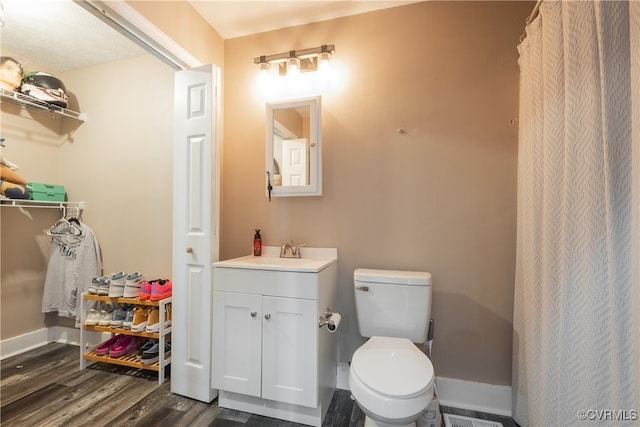 bathroom featuring toilet, vanity, and hardwood / wood-style flooring