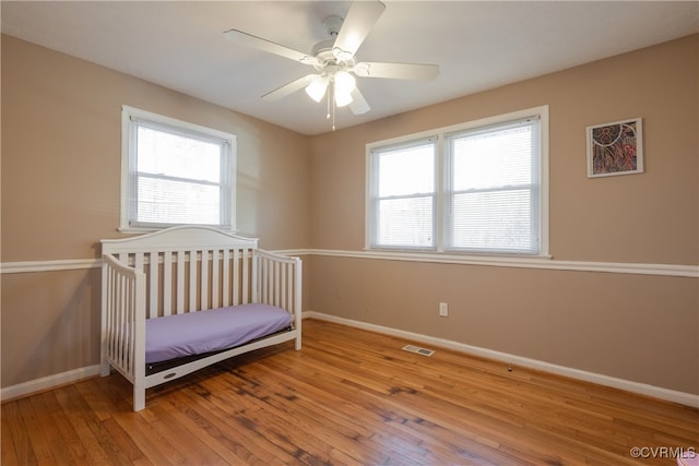 unfurnished bedroom with ceiling fan and light wood-type flooring