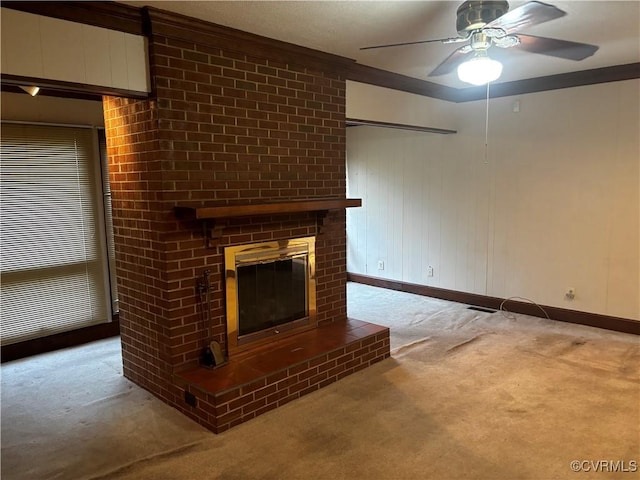 unfurnished living room with carpet flooring, ceiling fan, a fireplace, and ornamental molding