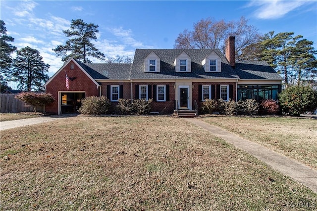 new england style home featuring a front yard and a garage