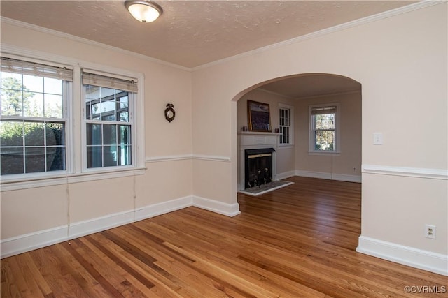 unfurnished living room with crown molding, hardwood / wood-style floors, and a textured ceiling