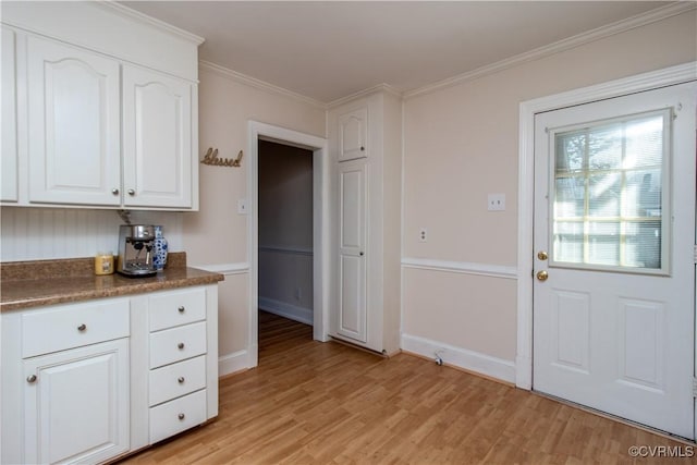 kitchen with light hardwood / wood-style floors, white cabinetry, and crown molding