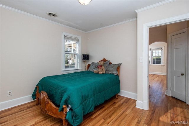 bedroom with crown molding and light hardwood / wood-style flooring