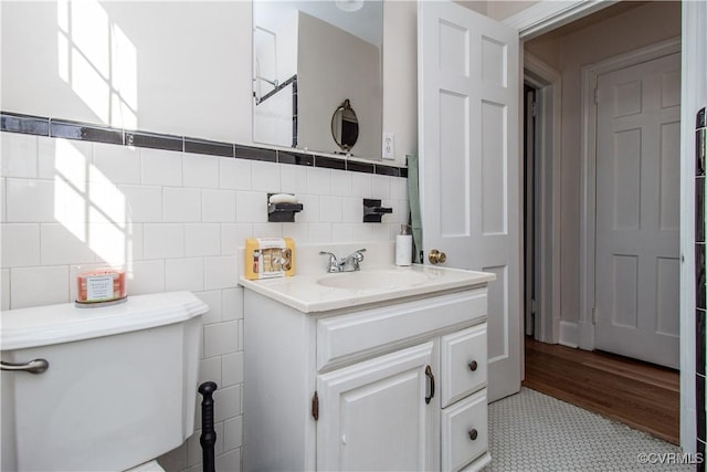 bathroom with tile patterned flooring, vanity, tile walls, and toilet