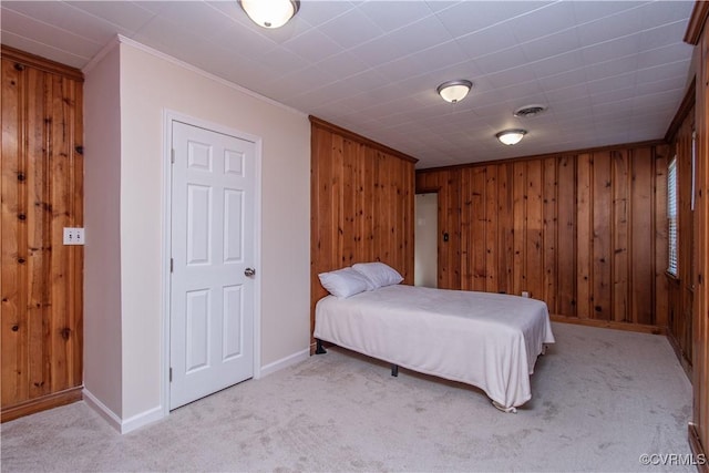 bedroom with ornamental molding, light carpet, and wooden walls