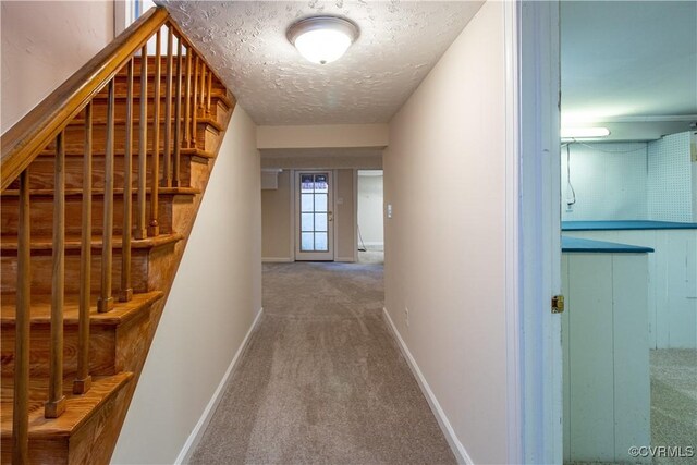 hallway with carpet floors and a textured ceiling