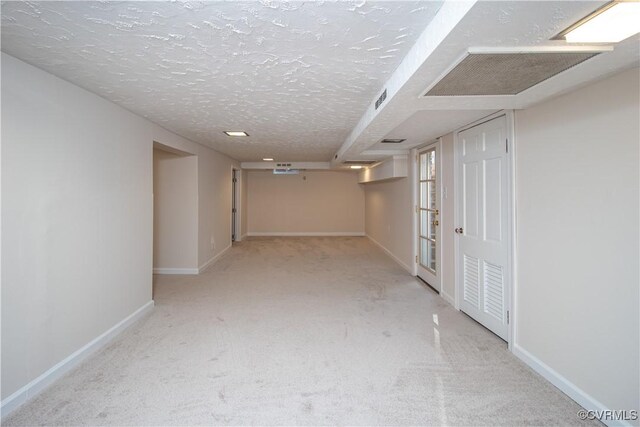 hall with carpet flooring and a textured ceiling