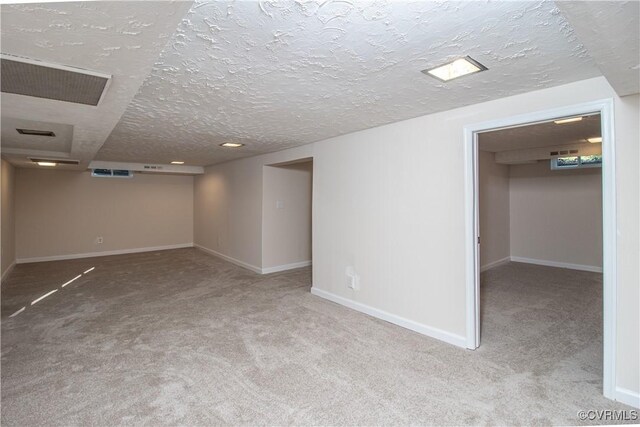 basement with a textured ceiling and light colored carpet