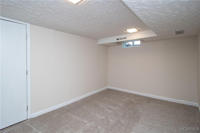 basement featuring carpet floors and a textured ceiling