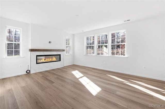 unfurnished living room with light wood-type flooring and a wealth of natural light