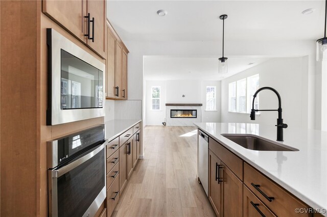 kitchen with sink, plenty of natural light, decorative light fixtures, and appliances with stainless steel finishes