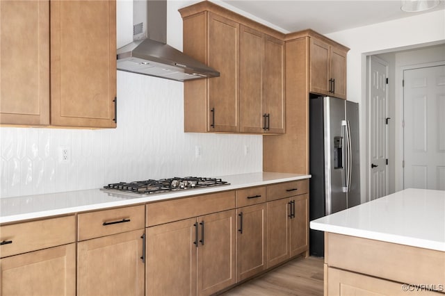 kitchen with wall chimney exhaust hood, stainless steel appliances, and light hardwood / wood-style flooring