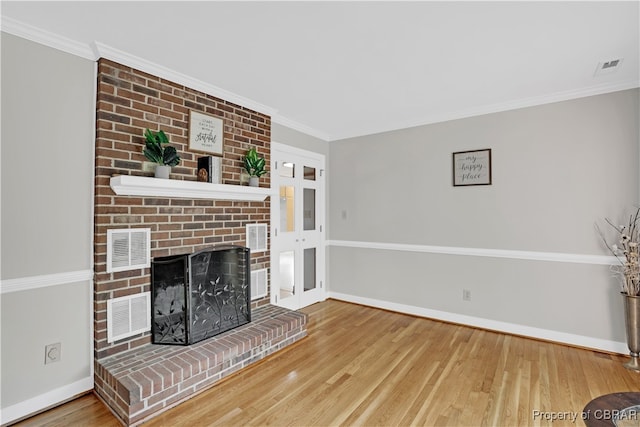 unfurnished living room with a brick fireplace, ornamental molding, and hardwood / wood-style flooring