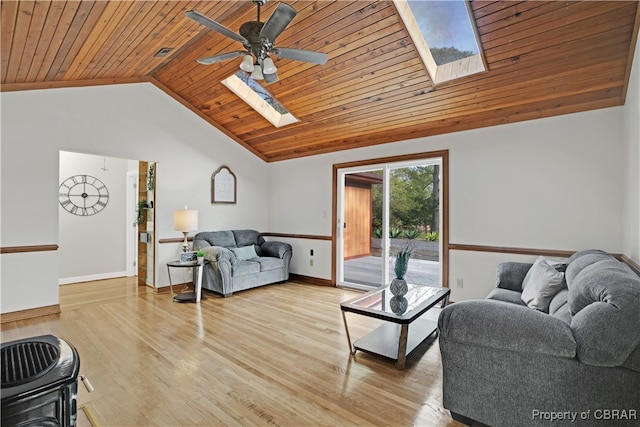 living room featuring vaulted ceiling with skylight, light hardwood / wood-style floors, ceiling fan, and wood ceiling