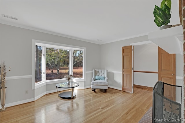 living area featuring hardwood / wood-style floors and ornamental molding