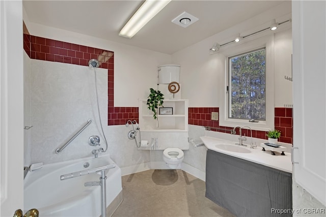 full bathroom with tiled shower / bath, vanity, toilet, and tile walls