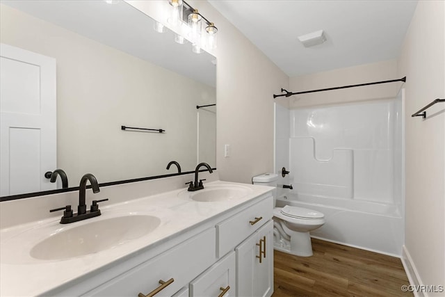 full bathroom with hardwood / wood-style floors, vanity, toilet, and shower / bathing tub combination