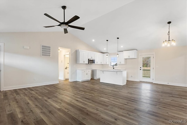 kitchen featuring white cabinets, dark hardwood / wood-style flooring, hanging light fixtures, and lofted ceiling