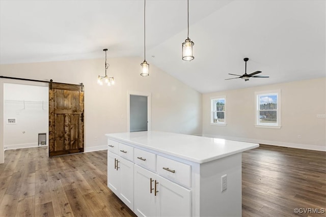 kitchen featuring white cabinetry, a center island, hanging light fixtures, a barn door, and hardwood / wood-style flooring