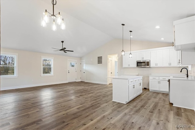 kitchen with pendant lighting, ceiling fan, light wood-type flooring, and white cabinetry