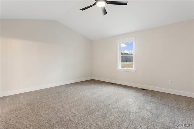 carpeted spare room with ceiling fan and vaulted ceiling