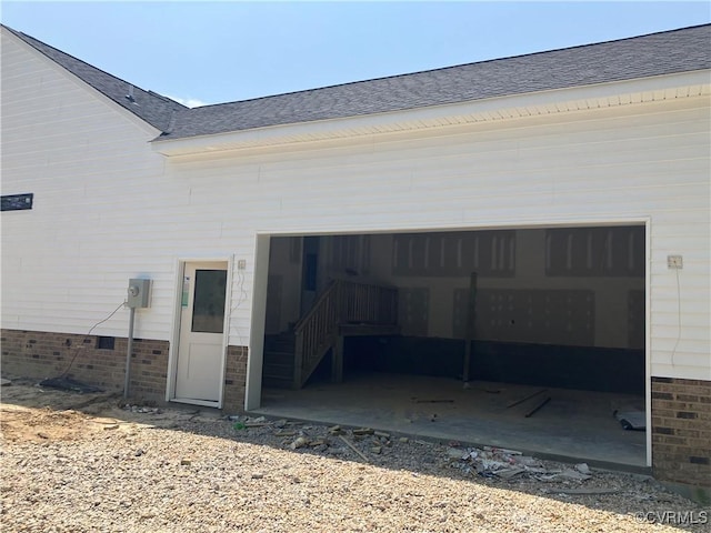 14310 Meadow Ln, Disputanta, VA 23842 - back of property featuring a shingled roof, an attached garage, and brick siding
