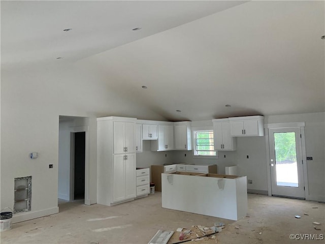 14310 Meadow Ln, Disputanta, VA 23842 - kitchen with a kitchen island, vaulted ceiling, and white cabinetry