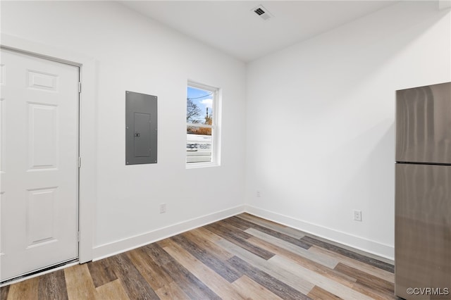 empty room featuring electric panel and hardwood / wood-style flooring